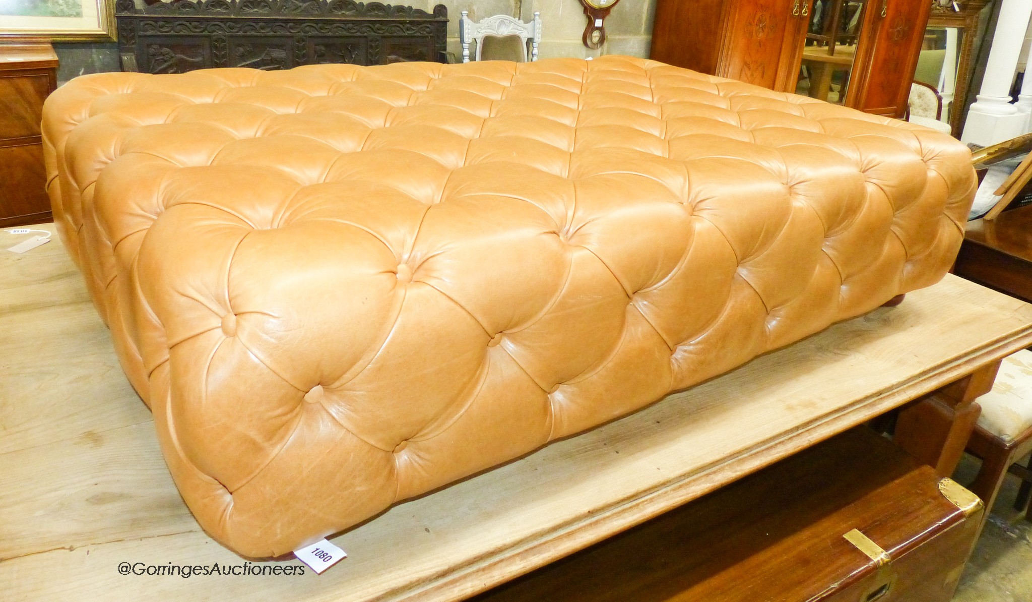 A large Victorian style buttoned tan leather footstool, length 140cm, depth 94cm, height 35cm